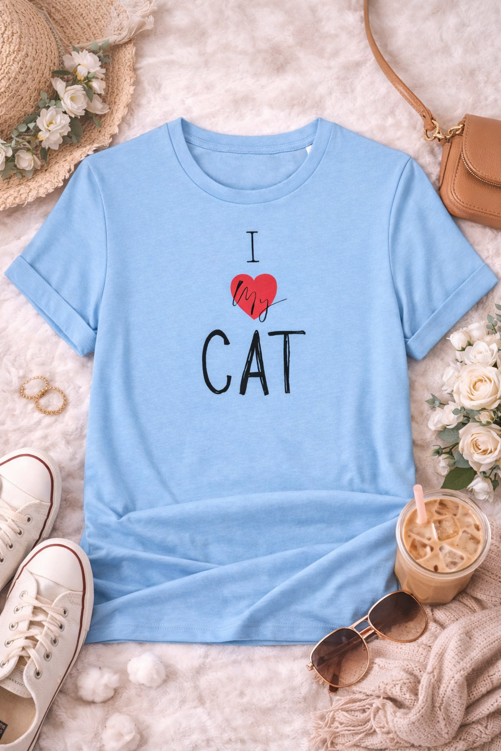 Light blue t-shirt with I love my cat text on a textured surface with accessories.
