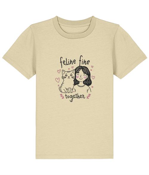 Beige t-shirt with a graphic of a woman and cat with 'feline fine together' text on a white background
